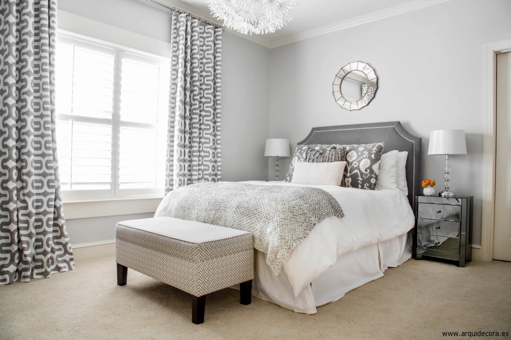 Dormitorio decorado en tonos grises y blancos, con moqueta beige